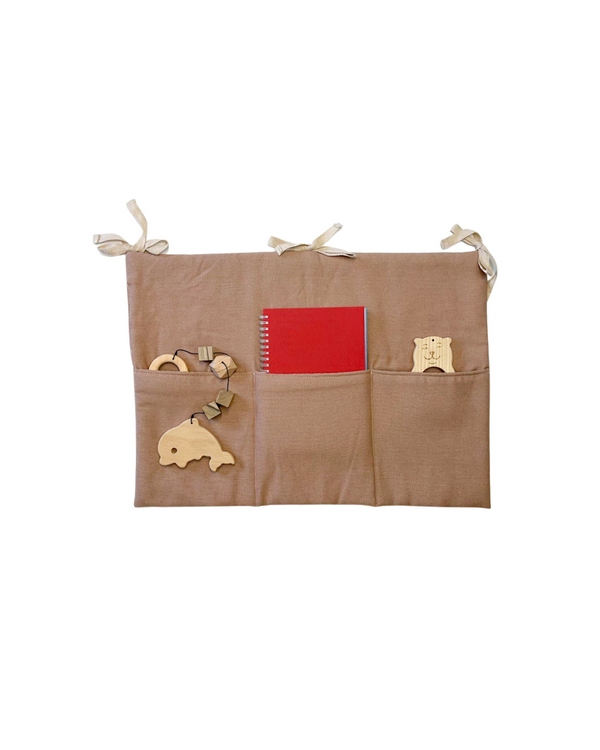 Taupe linen crib toy pocket with three compartments and cotton ties for nursery organization