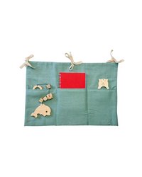Sage green linen toy pocket with three compartments and fabric ties, hanging on a crib Linen toy pocket | Sage green hellolittlefox linen-toy-pocket-sage-green hellolittlefox.myshopify.com