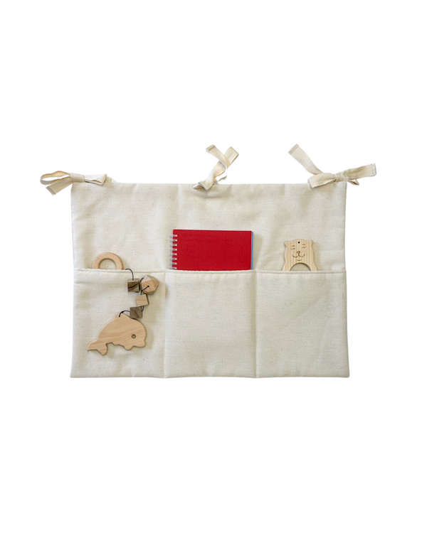 Off white linen crib toy pocket with three compartments, hanging from a crib rail Linen toy pocket | Off White hellolittlefox linen-toy-pocket-off-white hellolittlefox.myshopify.com