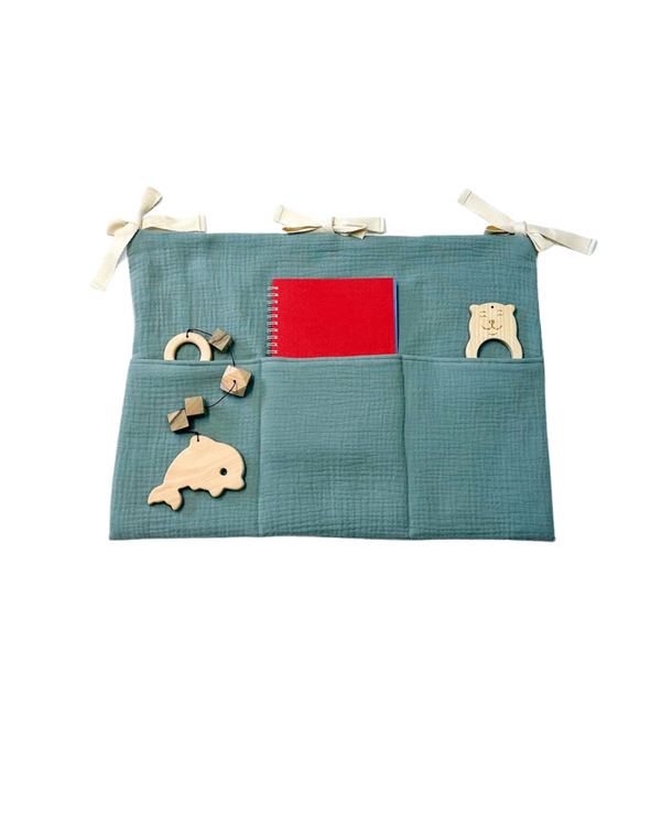 Sage green muslin hanging organizer with three pockets for toys and baby items