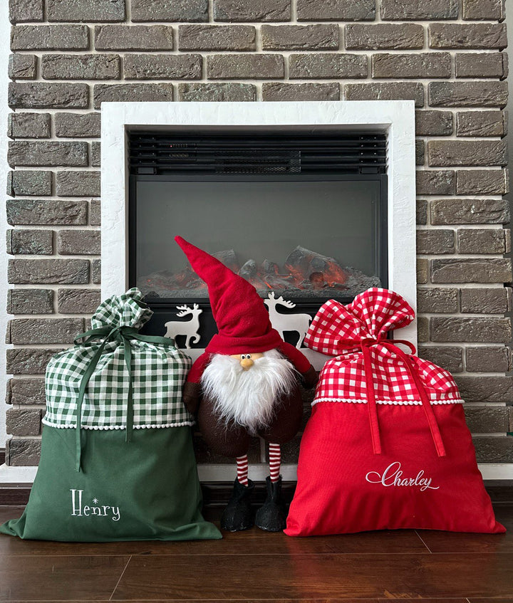 Personalized red Santa sack hanging near fireplace