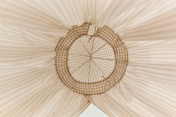 Beige gingham crib canopy in a cozy baby room