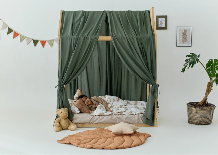 Khaki linen bed canopy draped over a Montessori house bed